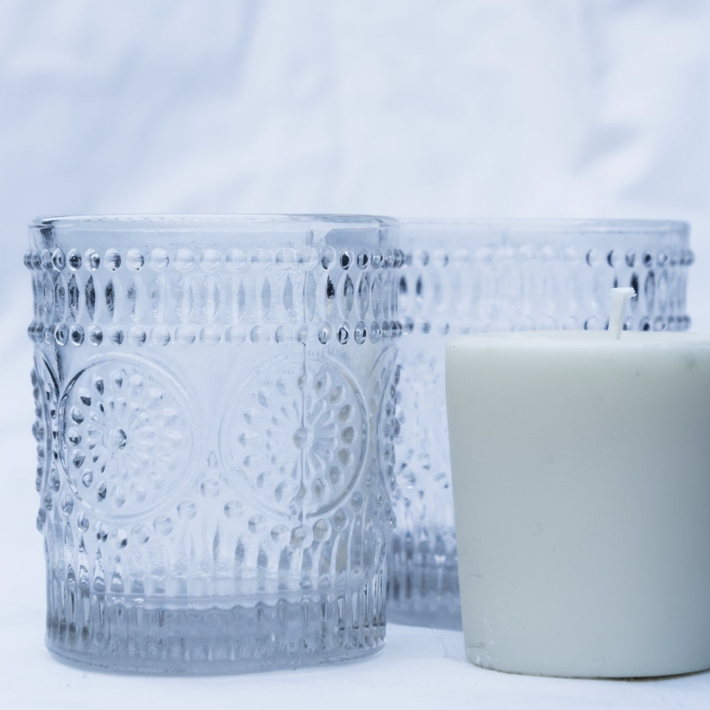 Decorative votives candle holders with a white candle on a light gray background