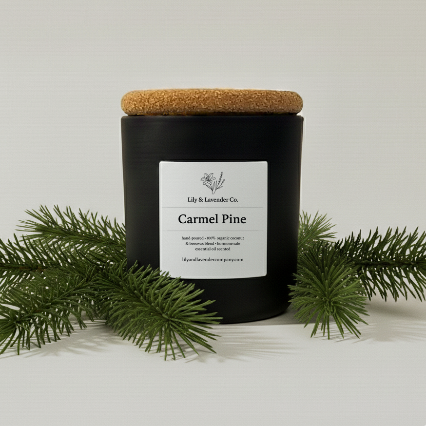 Lily & Lavender Co. Carmel Pine Essential Oil Scented, Non-Toxic Coconut & Beeswax Candle sitting with pine branches.