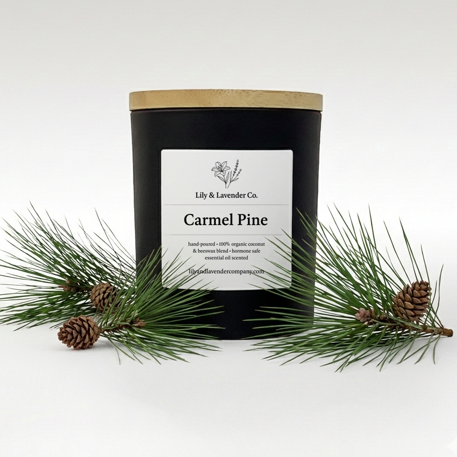 Lily & Lavender Co. Carmel Pine Essential Oil Scented, Non-Toxic Coconut & Beeswax Candle sitting with pine branches and pine cones.