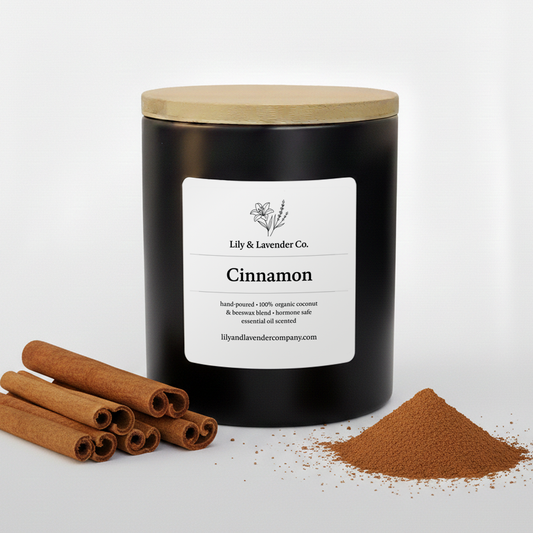 Lily & Lavender Co. Cinnamon, Essential Oil Scented, Non-Toxic Coconut & Beeswax Candle sitting with cinnamon sticks & cinnamon.