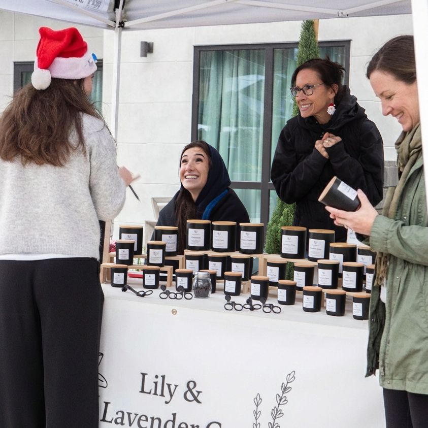 People interacting with a booth selling products branded as 'Lily & Lavender Co.'
