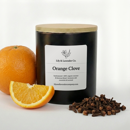 Non-Toxic Coconut & Beeswax Candle labeled 'Orange Clove' by Lily & Lavender Co. with an orange, orange slice, and cloves on a white background.